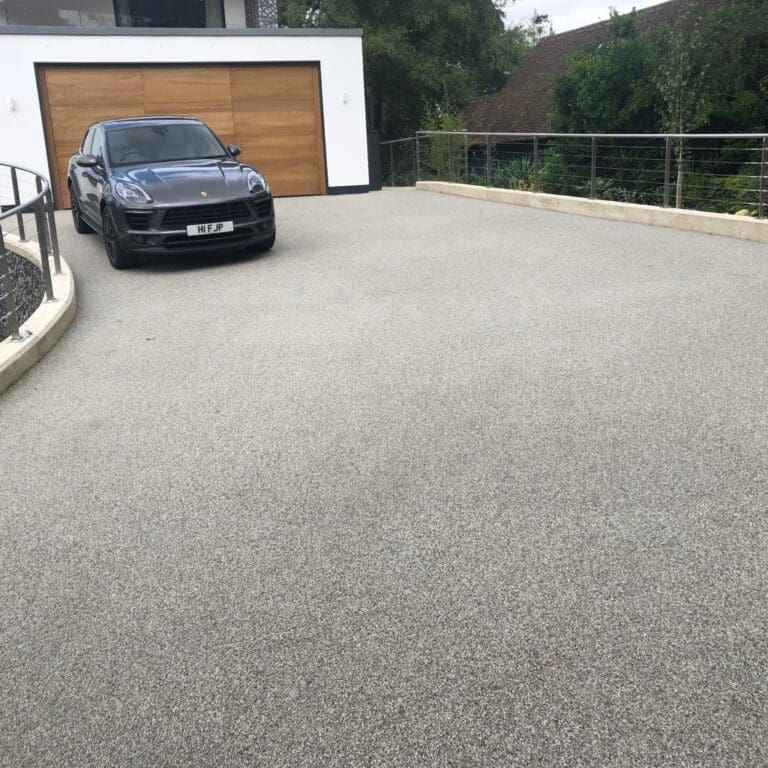 Grey resin driveway installation for garage entrance