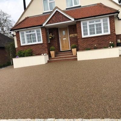 Light brown resin driveway installation for detached house