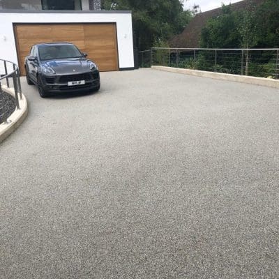 Grey resin driveway installation for garage entrance