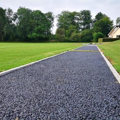 Tarmaced road leading down to a house
